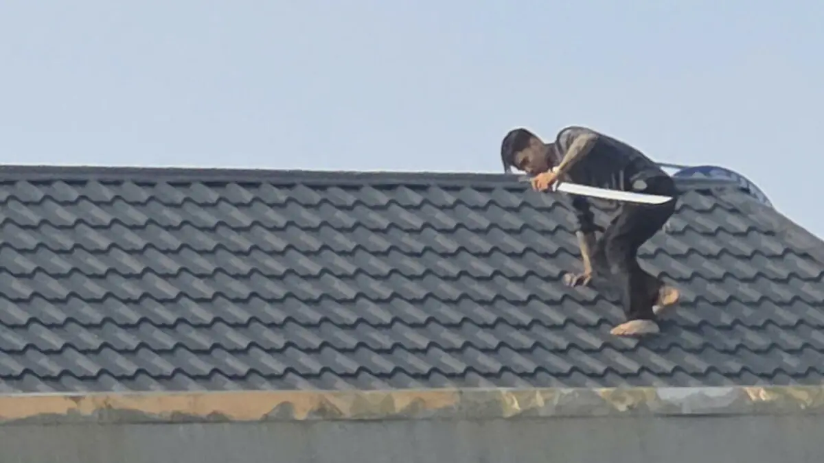 Hai người cầm kiếm cố thủ trên mái nhà là bị can ma túy đang bỏ trốn
